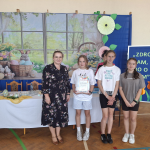 Uczennice szkoły wraz z opiekunem panią Sylwią prezentują uzyskany dyplom.