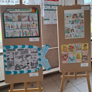 Na sztalugach prezentowane są 4 komiksy uczniów, którzy zdobyli wyróżnienia