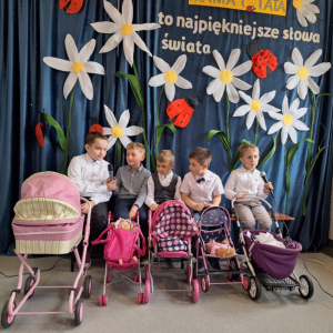 Chłopcy- tatusiowie z wózkami siedzą na ławce