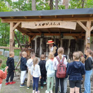 Dzieci stoją przed Zagrodą Garncarską w Łążku Garncarskim.