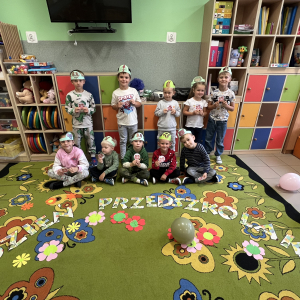 Dzieci pozują w opaskach zwierząt, trzymając certyfikaty z Dnia Przedszkolaka.