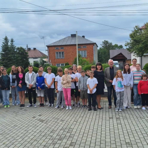 Uczniowie wraz z wychowawcami, dyrekcją i przybyłym gościem pozują do wspólnego zdjęcia.