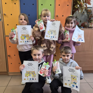 Najmłodsze dzieci stoją ze swoimi pracami -kolorowanki z tabliczka mnożenia