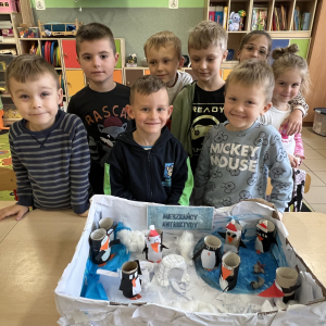  Przedszkolaki dumnie pozują przy własnoręcznie wykonanej makiecie z pingwinami. 