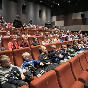 Uczniowie siedzą już na widowni, podekscytowani oczekiwaniem na rozpoczęcie spektaklu.
