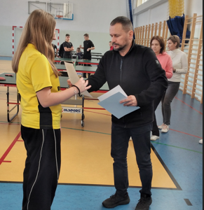 Kornelia odbiera nagrodę z rąk Powiatowego Organizatora Sportu Szkolnego Pana Maćka