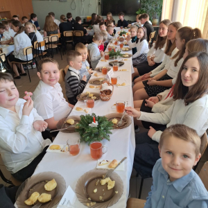 Uczniowie siedzą przy wspólnym stole.