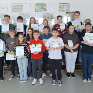 Uczniowie prezentują swoje dyplomy i nagrody.