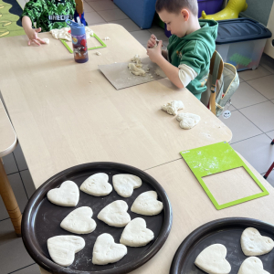 Dzieci układają prawie gotowe serca, które wkrótce wyschną i zostaną pomalowane.