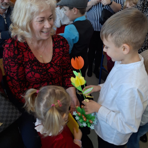 Babcia przyjmuje życzenia od wnuków.