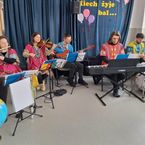 Artyści Mobilnej Filharmonii grają na instrumentach.