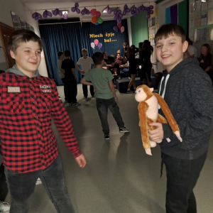 Uczniowie bawią się w kółeczku podając sobie maskotkę.