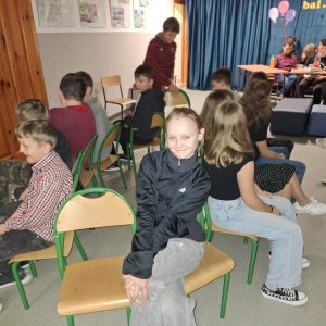 Uczniowie bawią się w zabawę z krzesełkami.