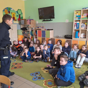 Uczniowie klas 0- 5 uczestniczą w spotkaniu z policjantem.