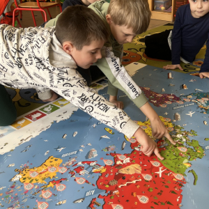 Dzieci wspólnie pokazują i omawiają kraje na plakacie Europy.