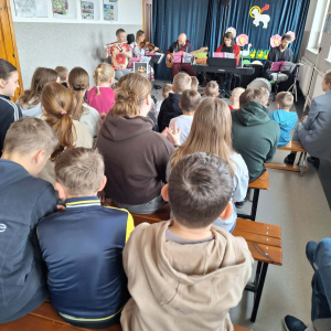 Dzieci siedzą i słuchają muzyki granej na żywo