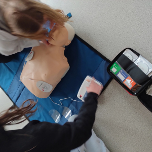 Uczniowie klasy 8 uczą się udzielania pierwszej pomocy na defibrylatorze  szkoleniowym AED XFT-120+ 