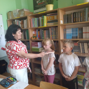 Pani bibliotekarka pasuje uczniów na czytelników