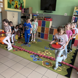 Uczniowie pokonują tor przeszkód, wykonują zadania z piłką i rozwijają swoją sprawność fizyczną.