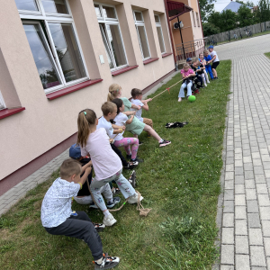 Dzieci z zaangażowaniem przeciągają linę, ćwicząc współpracę i ducha zespołowego.