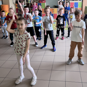 Dzieci tańczą przy muzyce, czerpiąc radość ze wspólnej zabawy.