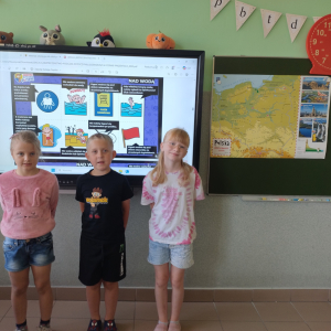 Pierwszaki pozują do wspólnego zdjęcia podczas realizacji programu edukacyjnego „Akademia Bezpiecznego Puchatka” 
