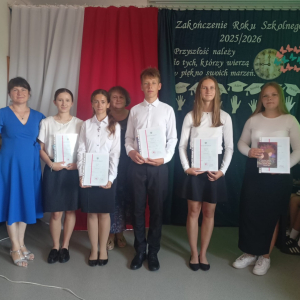 Uczniowie klasy VII prezentują otrzymane nagrody i świadectwa z wyróżnieniem.