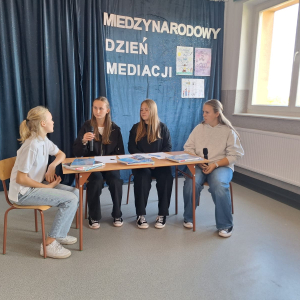 „Rozmowa zamiast sporu.”  Kadr z drugiej scenki pt. „Projekt dla jednego, ocena dla dwóch”. Podczas symulacji mediacji przy stole Sara i Kamila w obecności mediatorów szukały sprawiedliwego rozwiązania w sprawach trudnych emocjonalnie. To doskonały przykład na to, jak ważna jest bezpieczna przestrzeń i wysłuchanie racji obu stron.